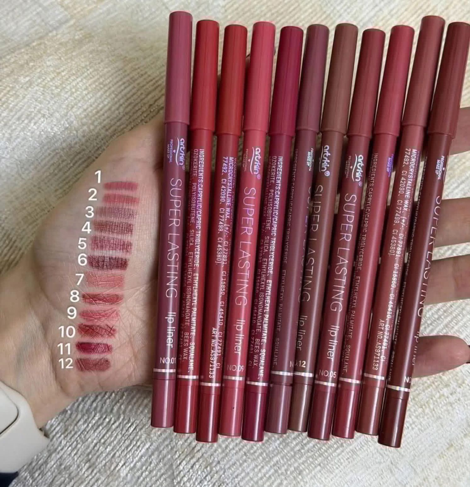 Set of Super Lasting lip liners with color swatches on a hand
